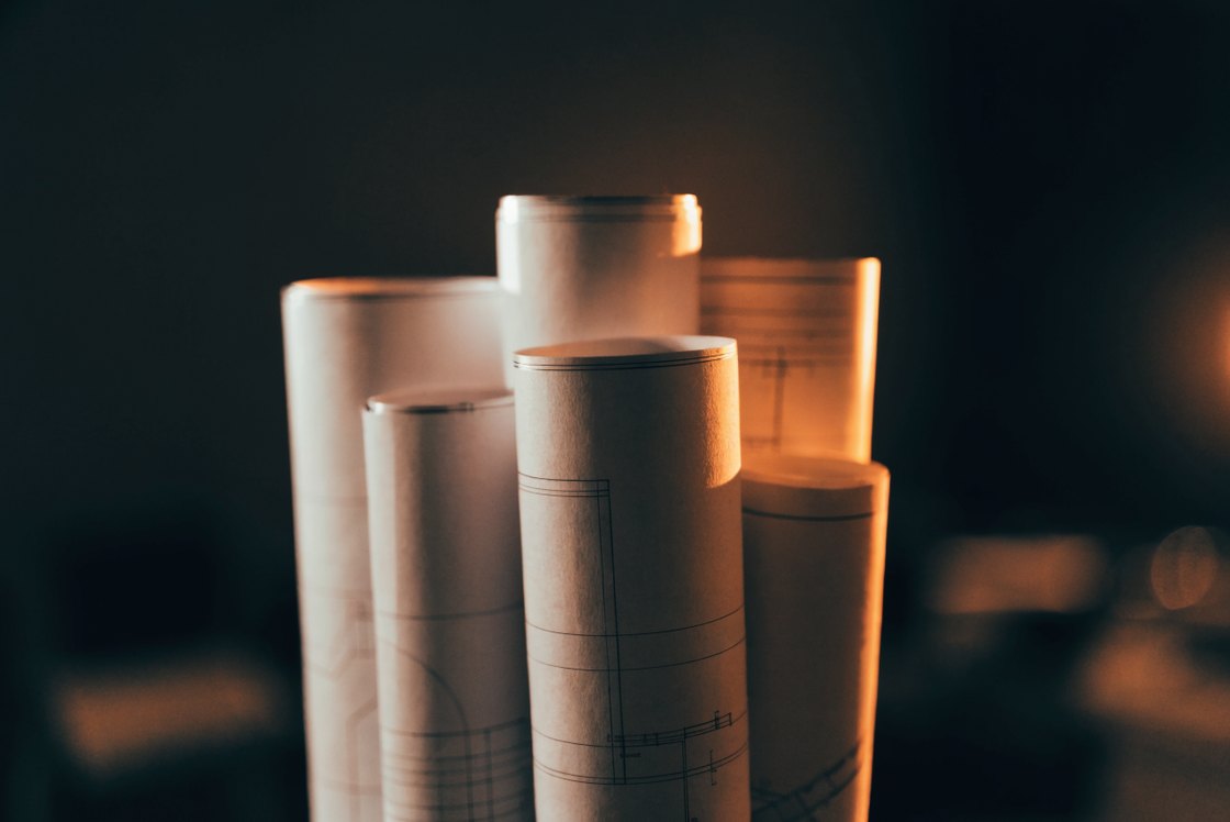 Rolled blueprint drawings in warm amber light